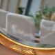 Old oval beveled wooden mirror, partly gilded and carved