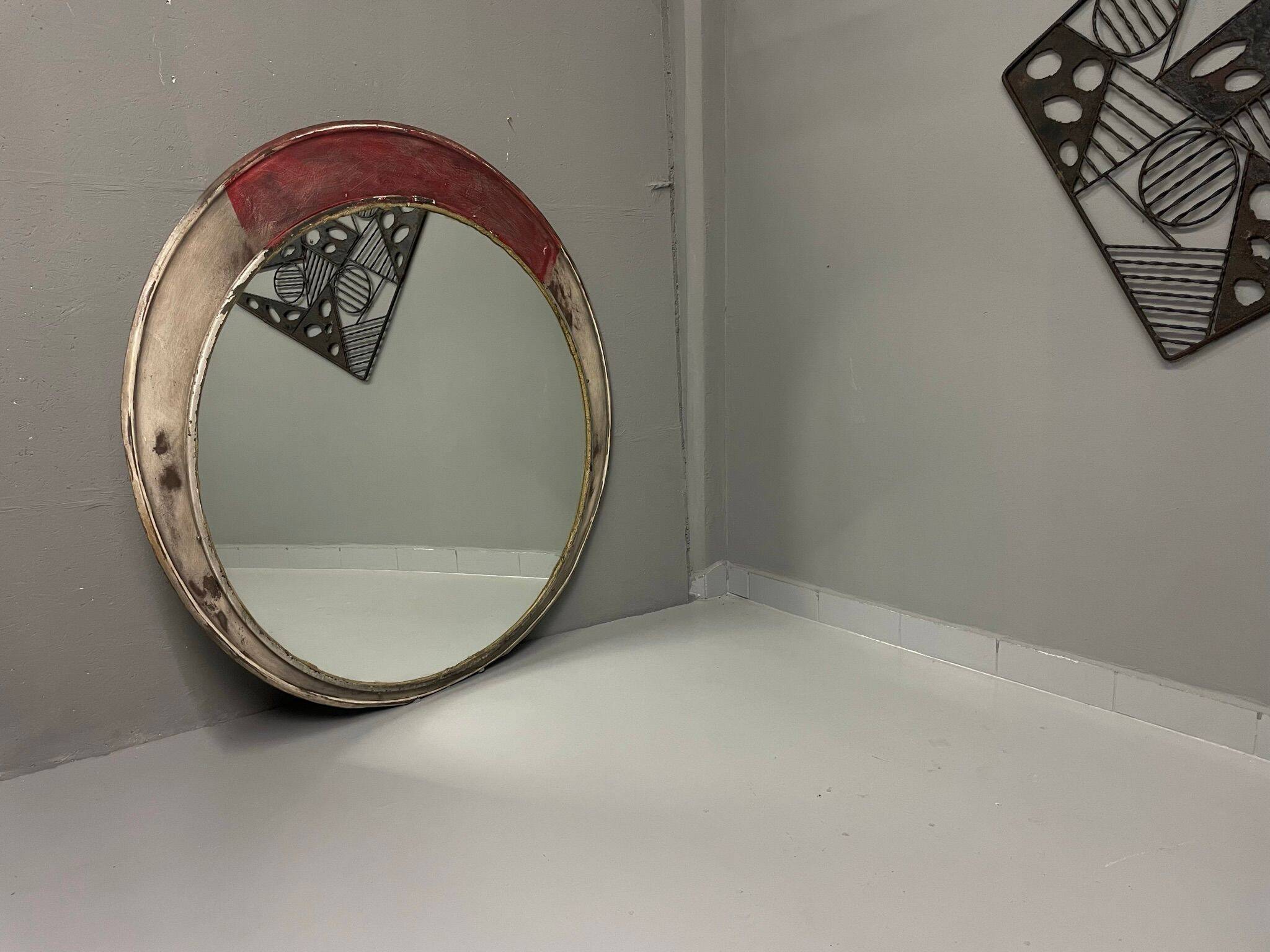 Vintage round mirror with an industrial metal frame in a painted finish.