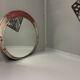 Vintage round mirror with an industrial metal frame in a painted finish.