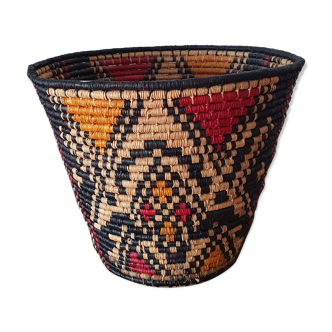 Ethnic basket in multicolored braided straw