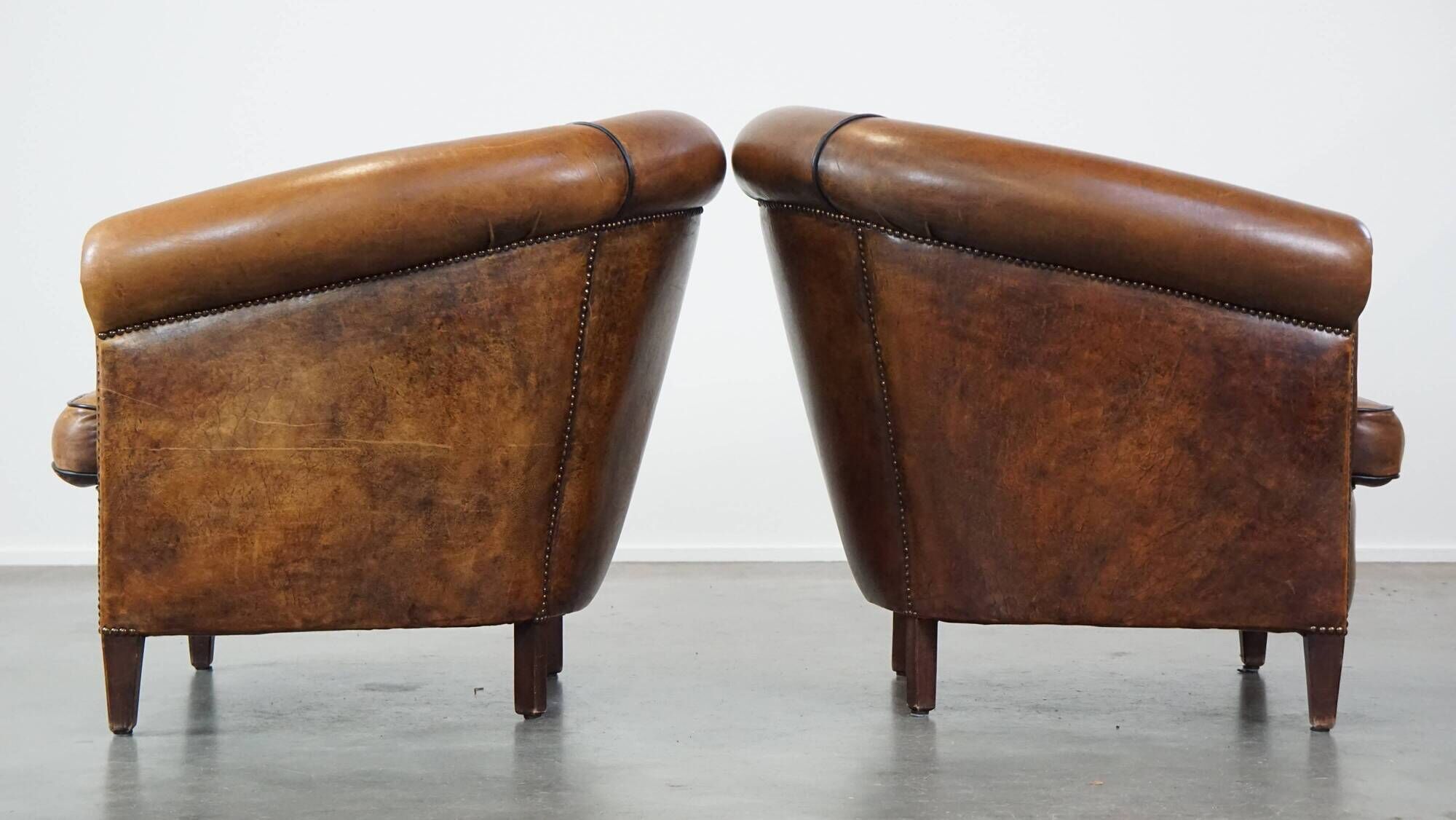 Set of 2 club armchairs in sheepskin leather with black piping