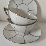 Two Art Deco porcelain cups and saucers with silver trim.