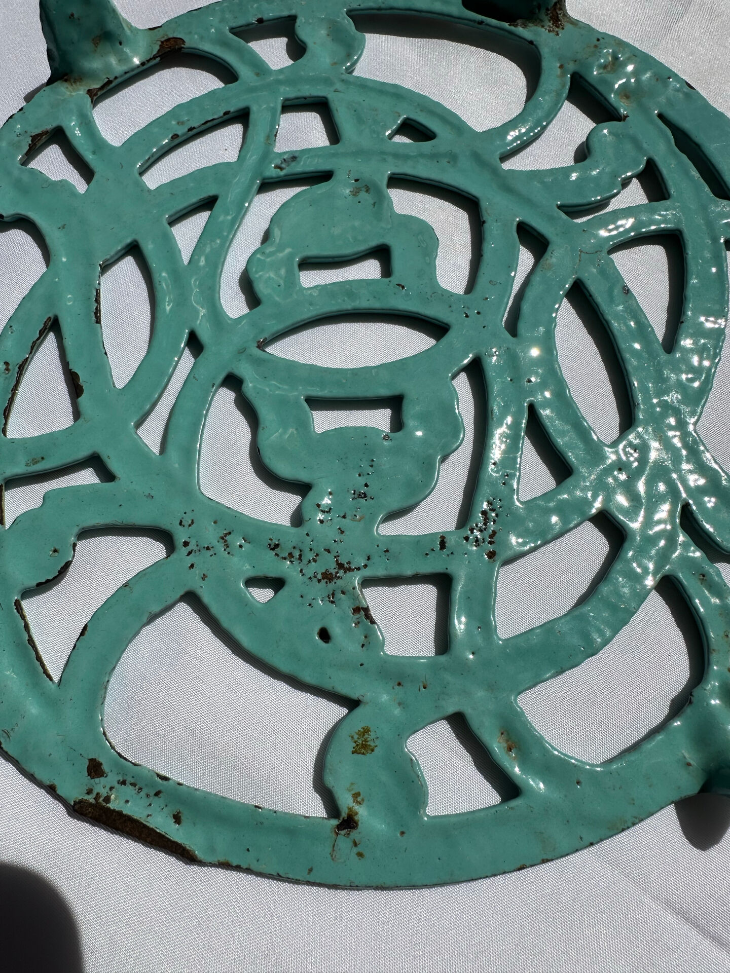 Enamelled cast iron trivet in blue with wrought iron decoration.