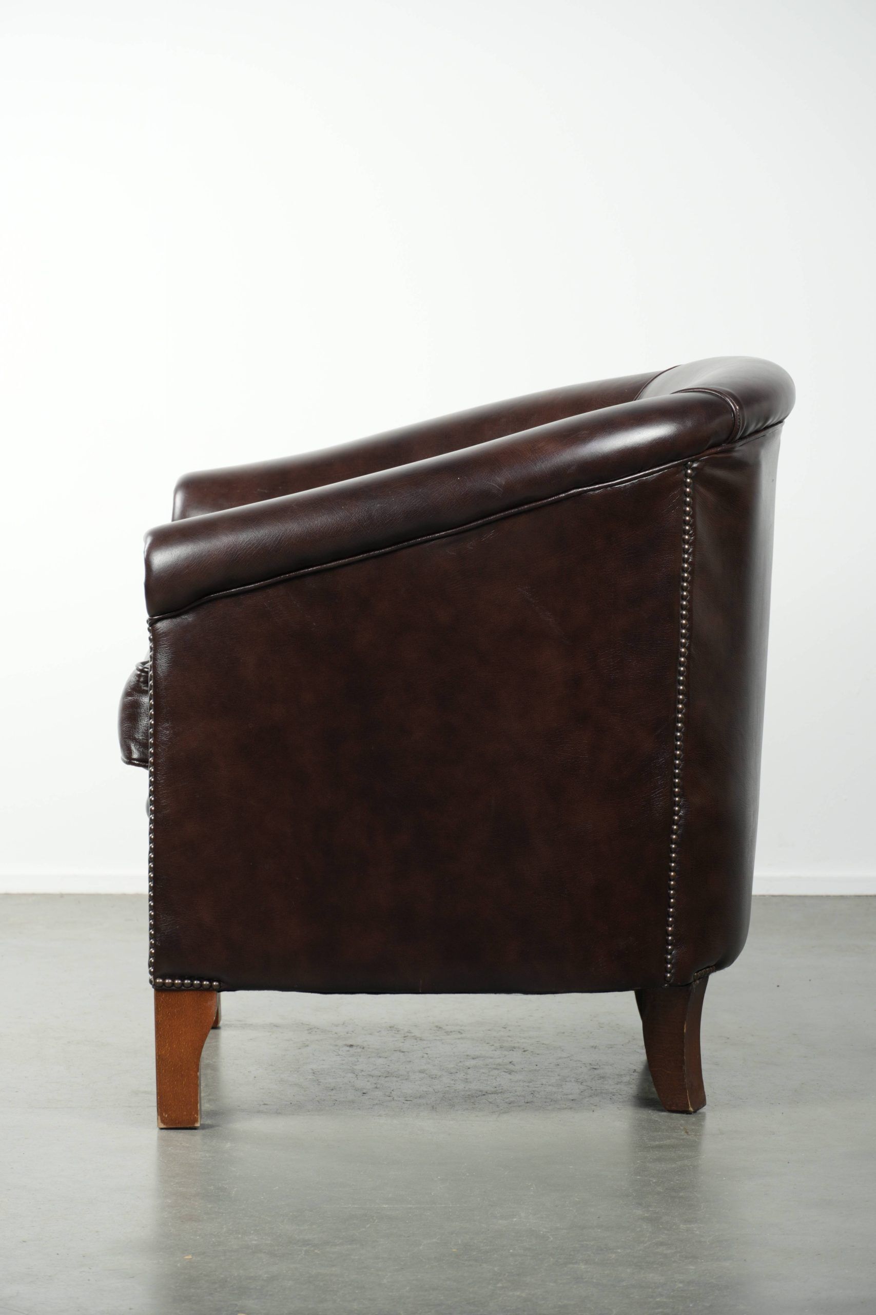 Dark cow leather club armchair in good condition with an English design