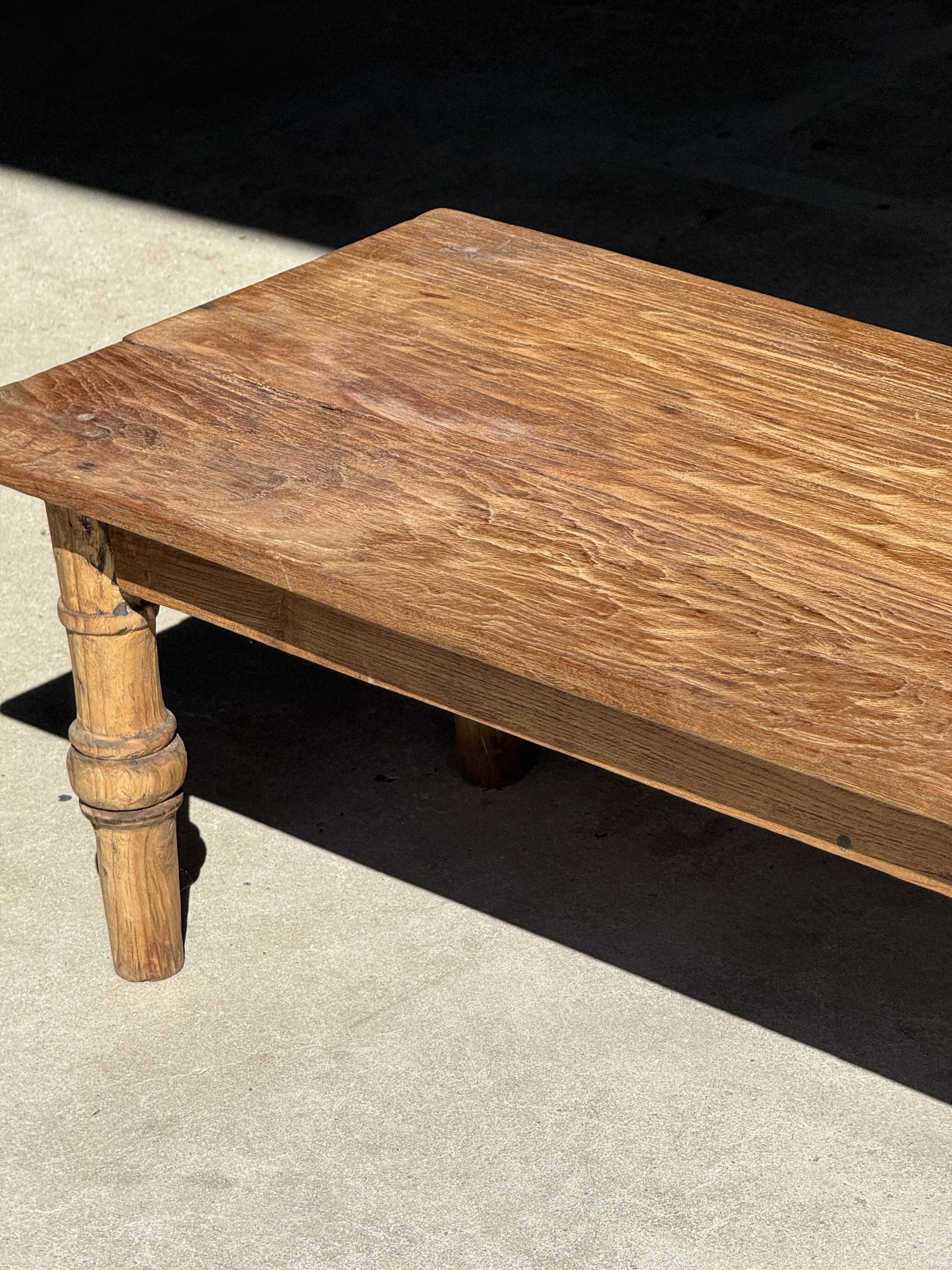 Brown Indonesian teak coffee table, with a border and cylindrical legs H40 L103.