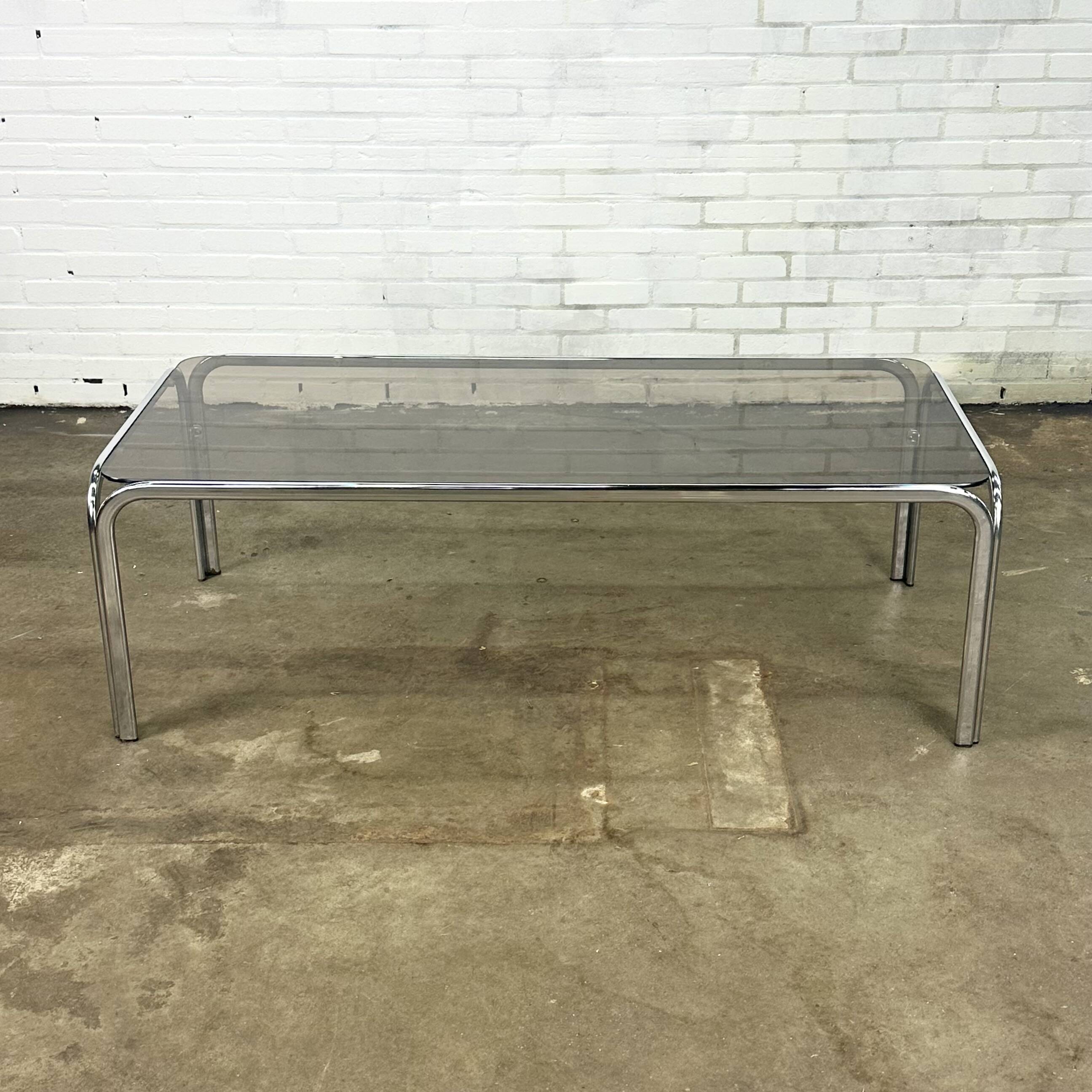 Table basse vintage à structure tubulaire et verre fumé