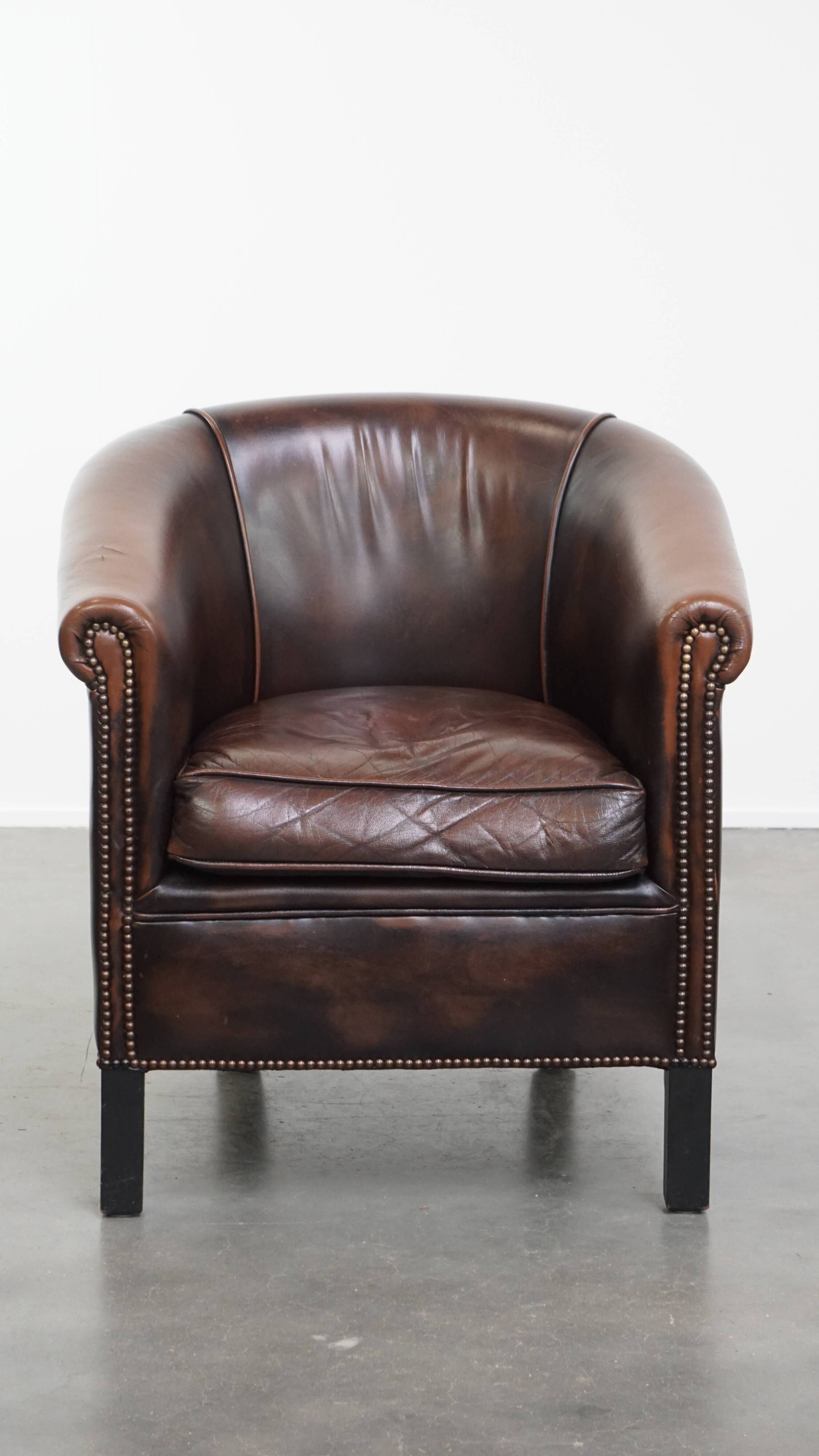 Fauteuil club de couleur foncée en cuir de vachette