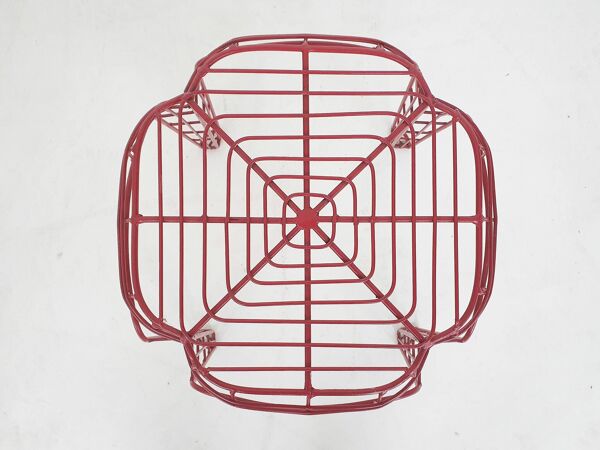 Ensemble de trois tabourets en fil métallique rouge.