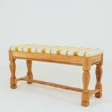 Vintage oak bench with striped linen fabric in a country style.