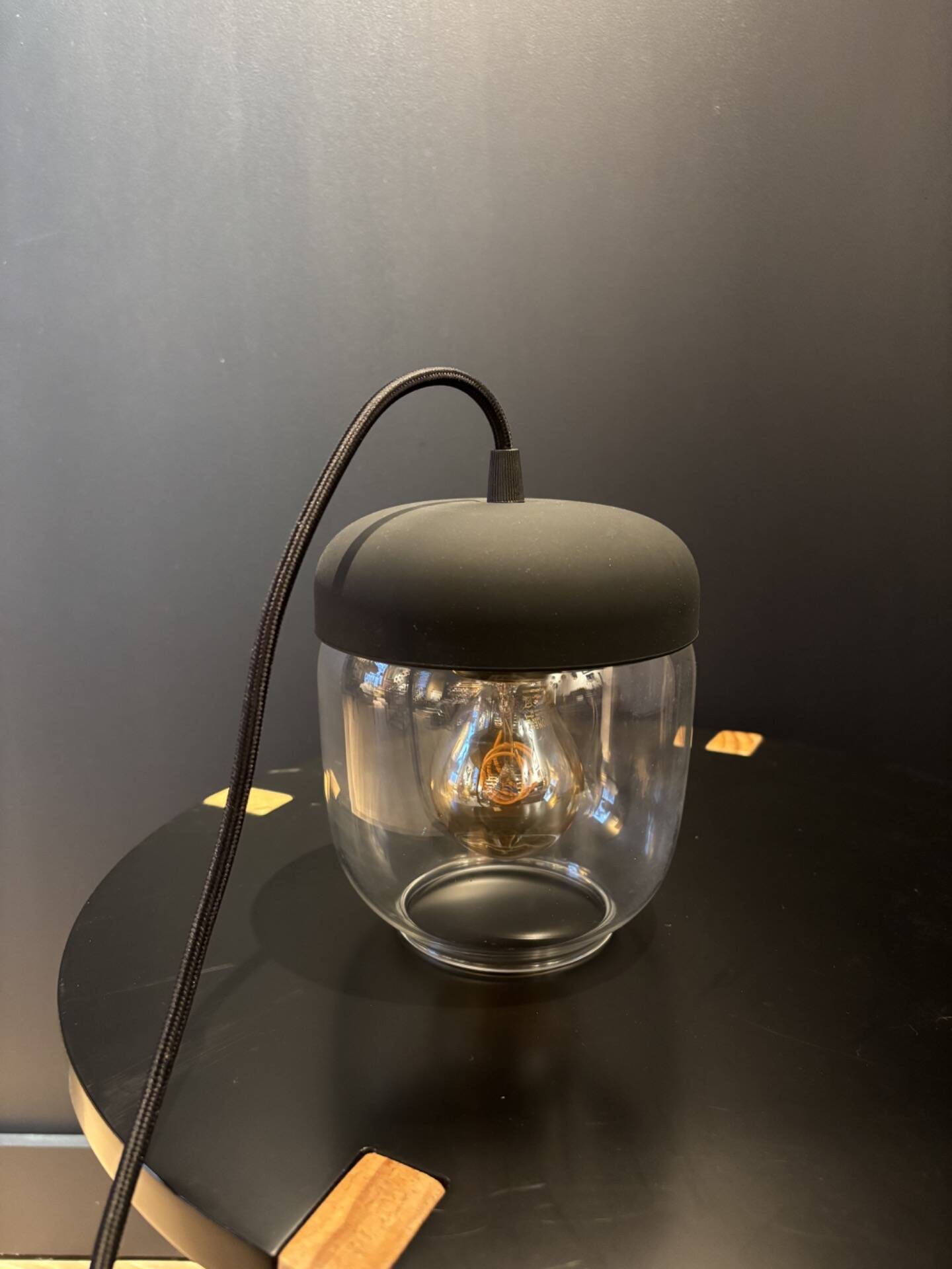 Portable lamp with transparent glass and black plastic.