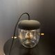 Portable lamp with transparent glass and black plastic.