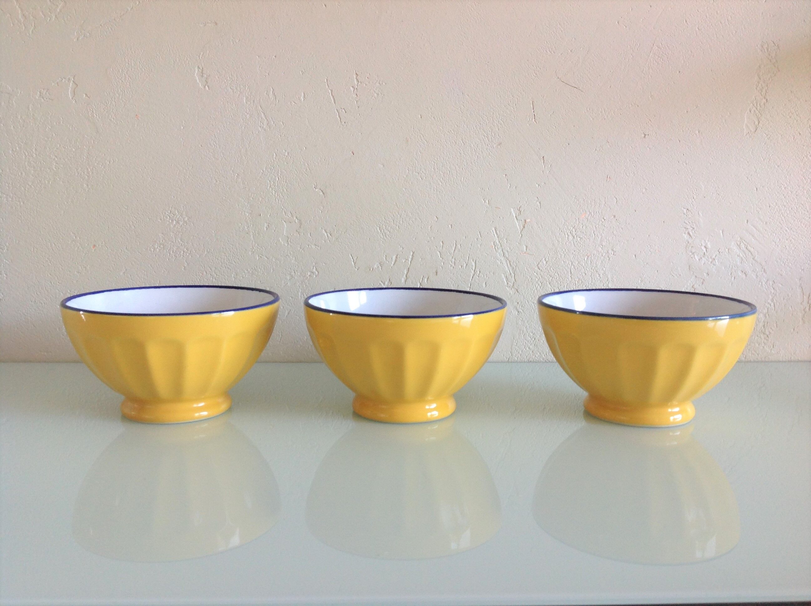 Suite of three yellow ribbed bowls with blue / vintage 70s border