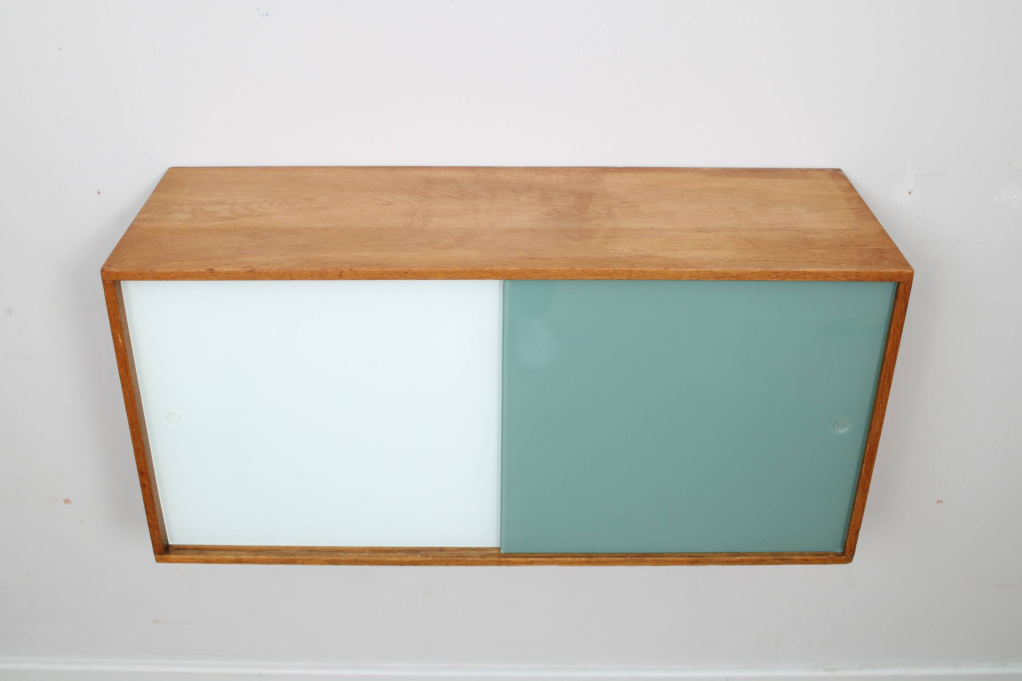 A vintage mid century wall hung bookcase/cabinet with glass sliding doors