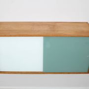 A vintage mid century wall hung bookcase/cabinet with glass sliding doors