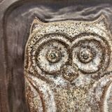 Small relief with a motif of an owl emerging from the back plate.