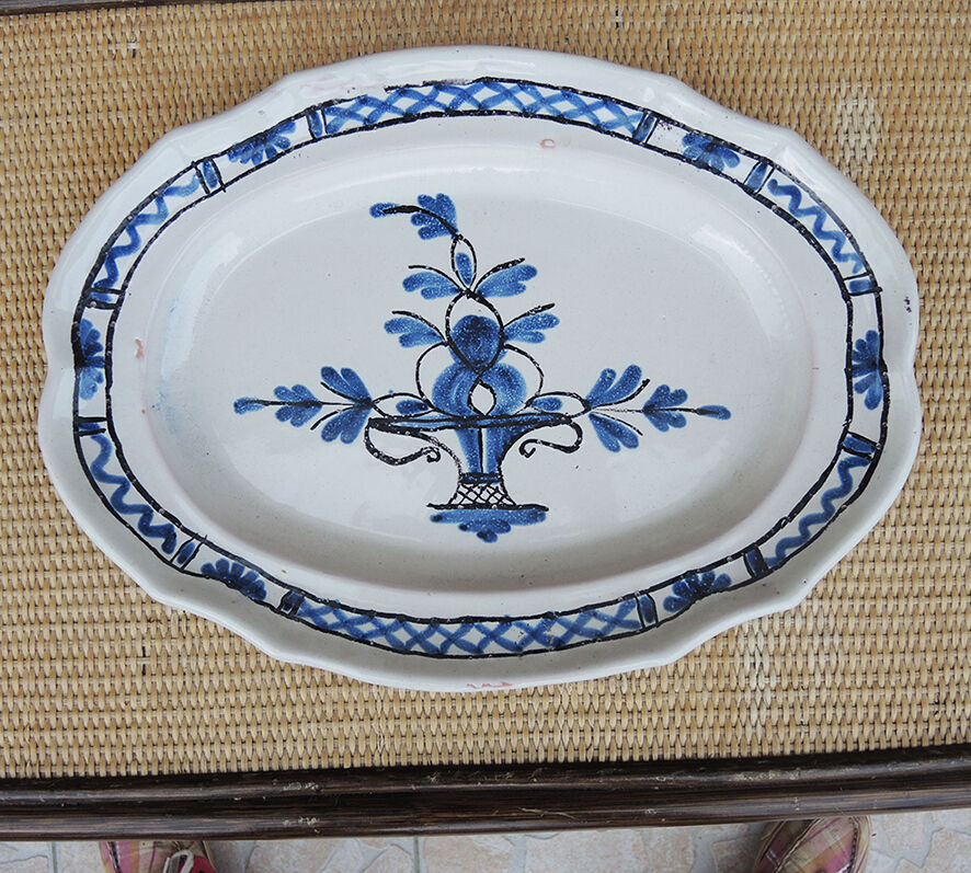 Old large oval ceramic dish with a black bottom.
