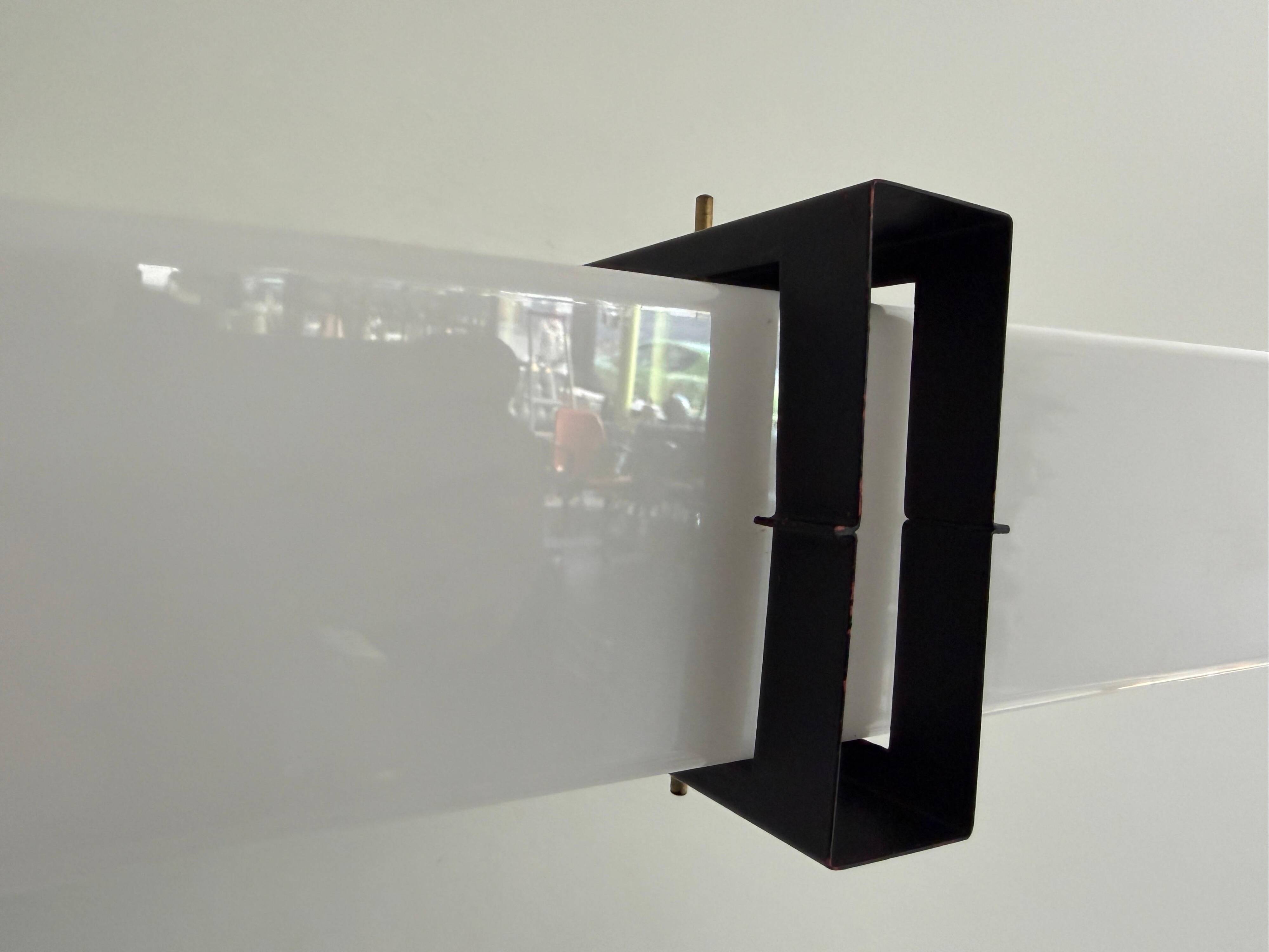 Simple white plexiglass wall light with a black metal frame, 1970s, Germany.