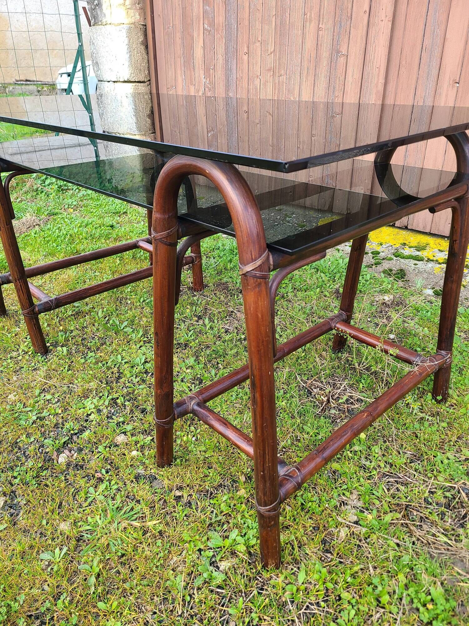 Smoked glass desk on rattan legs and leather detail