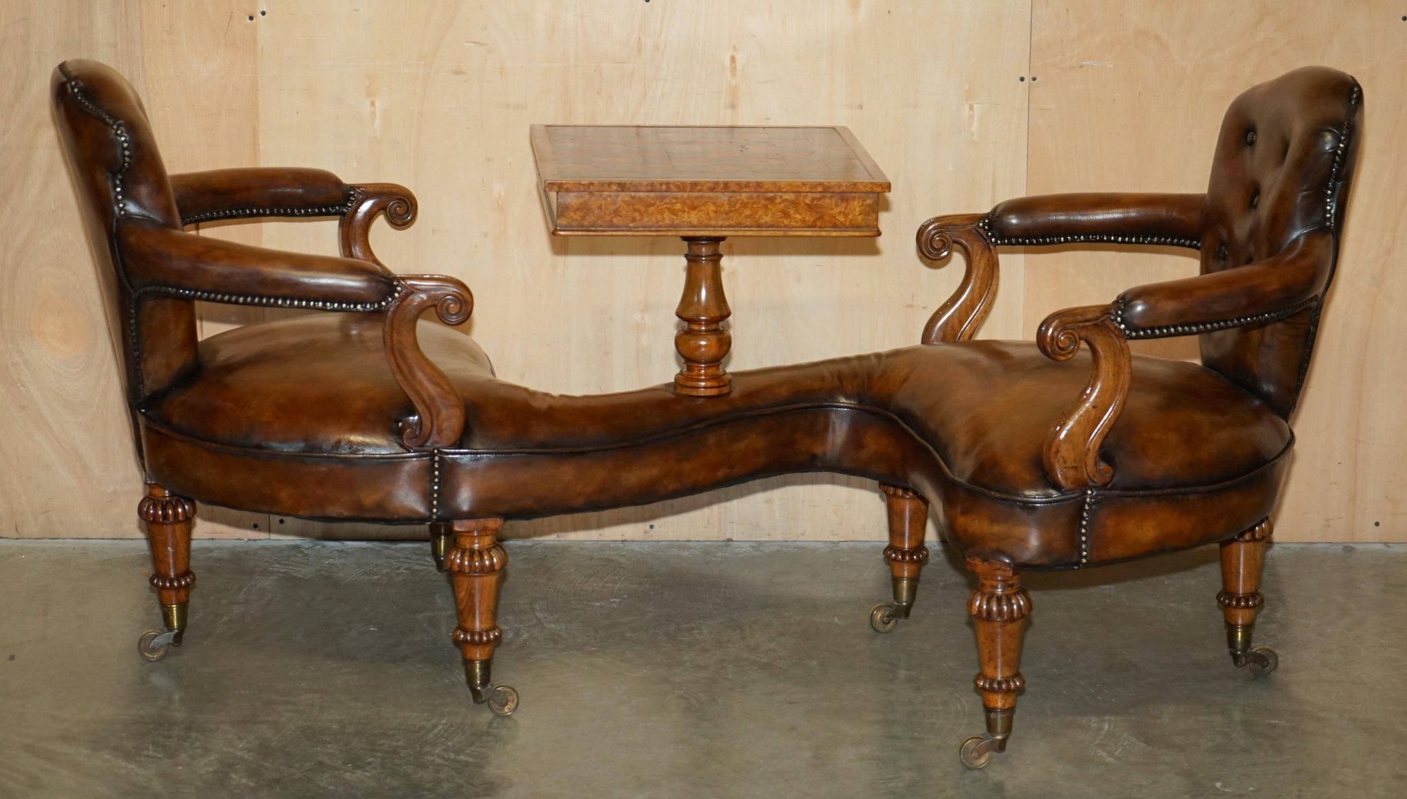 High Victorian leather tête-à-tête canapé with a walnut burr chessboard.