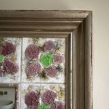 Large square ceramic mirror with floral decoration.