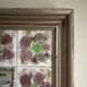 Large square ceramic mirror with floral decoration.