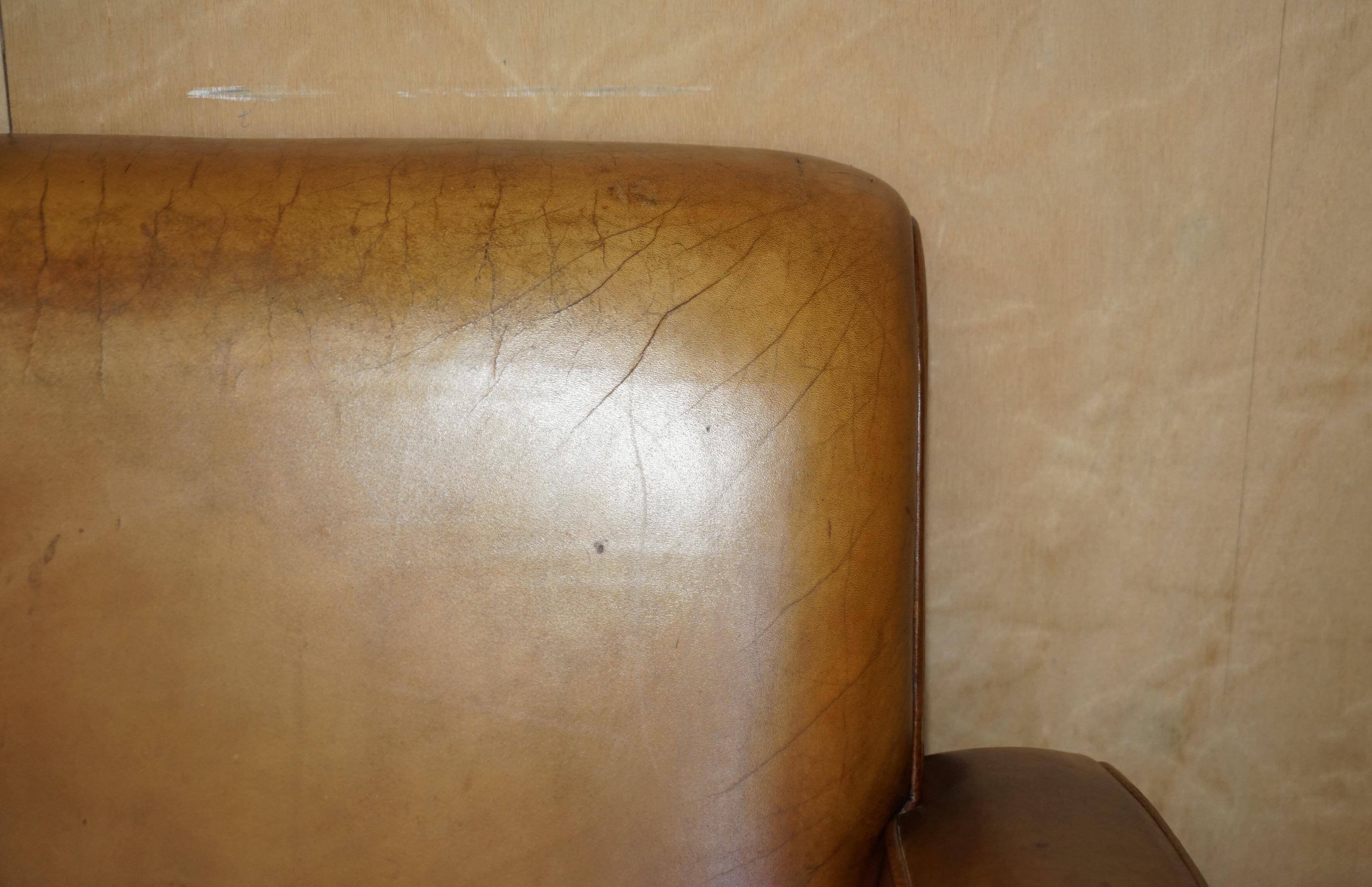 Three-seater Art Deco style leather sofa with feather cushions.