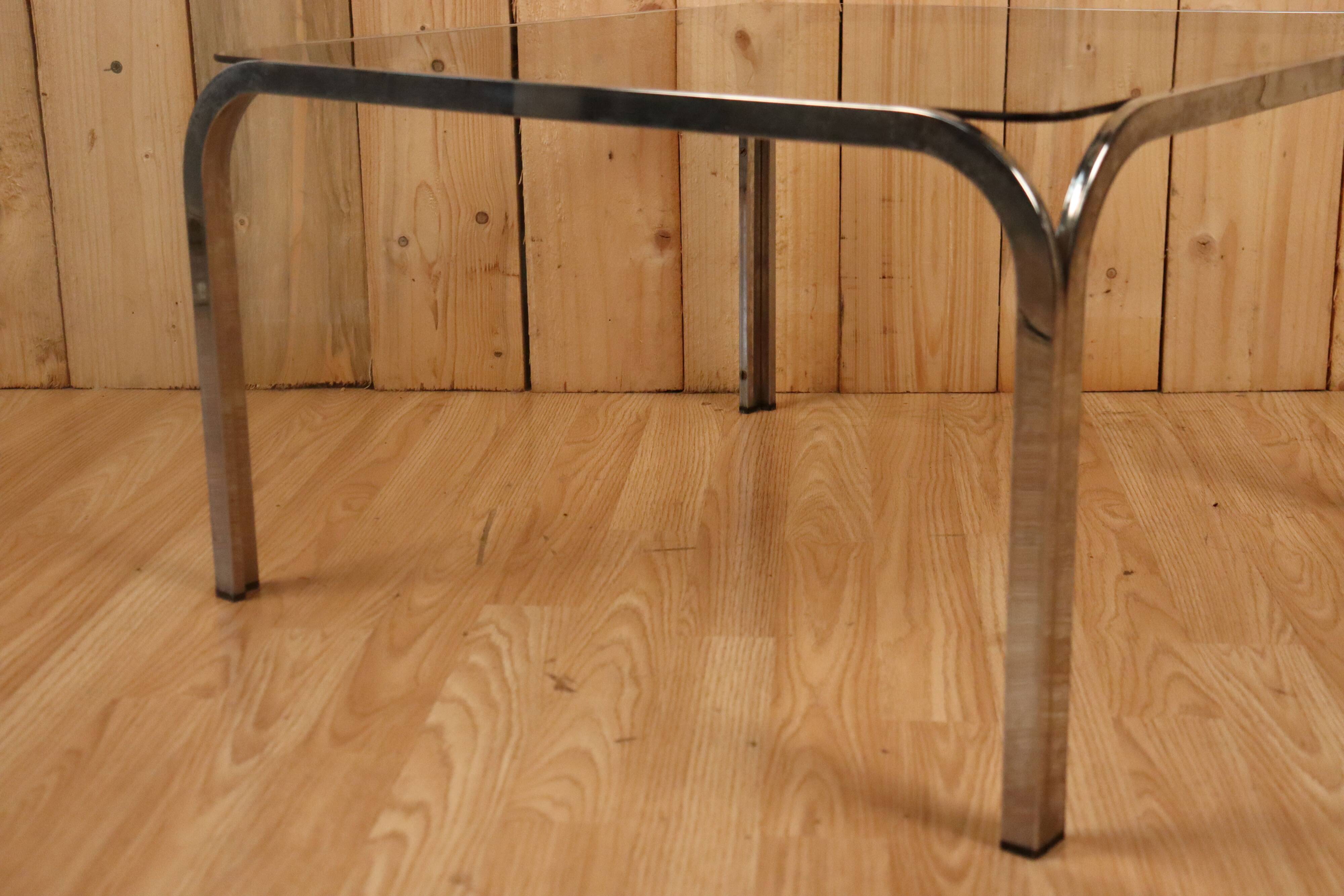 Table basse verre fumé et acier tubulaire.