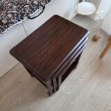Nested tables made of varnished solid wood.