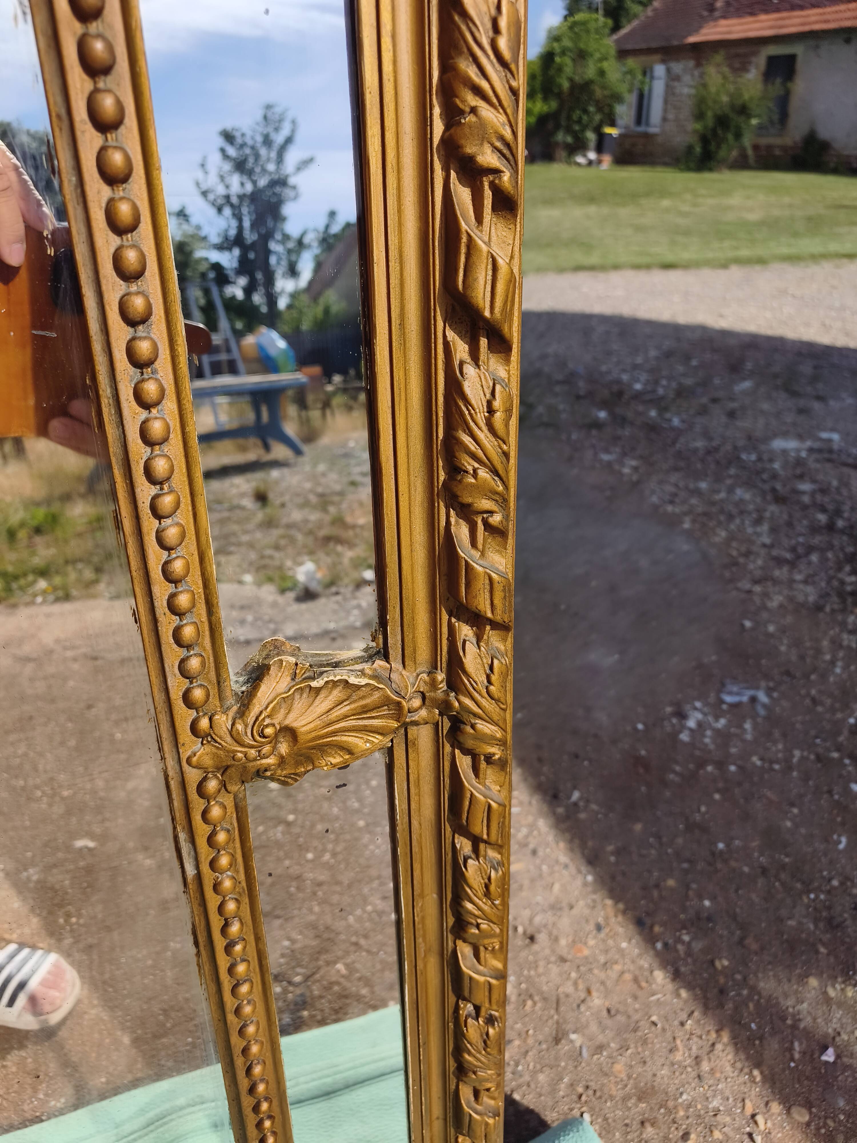 Large closed mirror, 19th century, wood and gilded stucco.