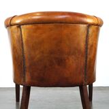 Neat and subtle sheepskin club chair, finished with decorative studs and a fixed seat cushion