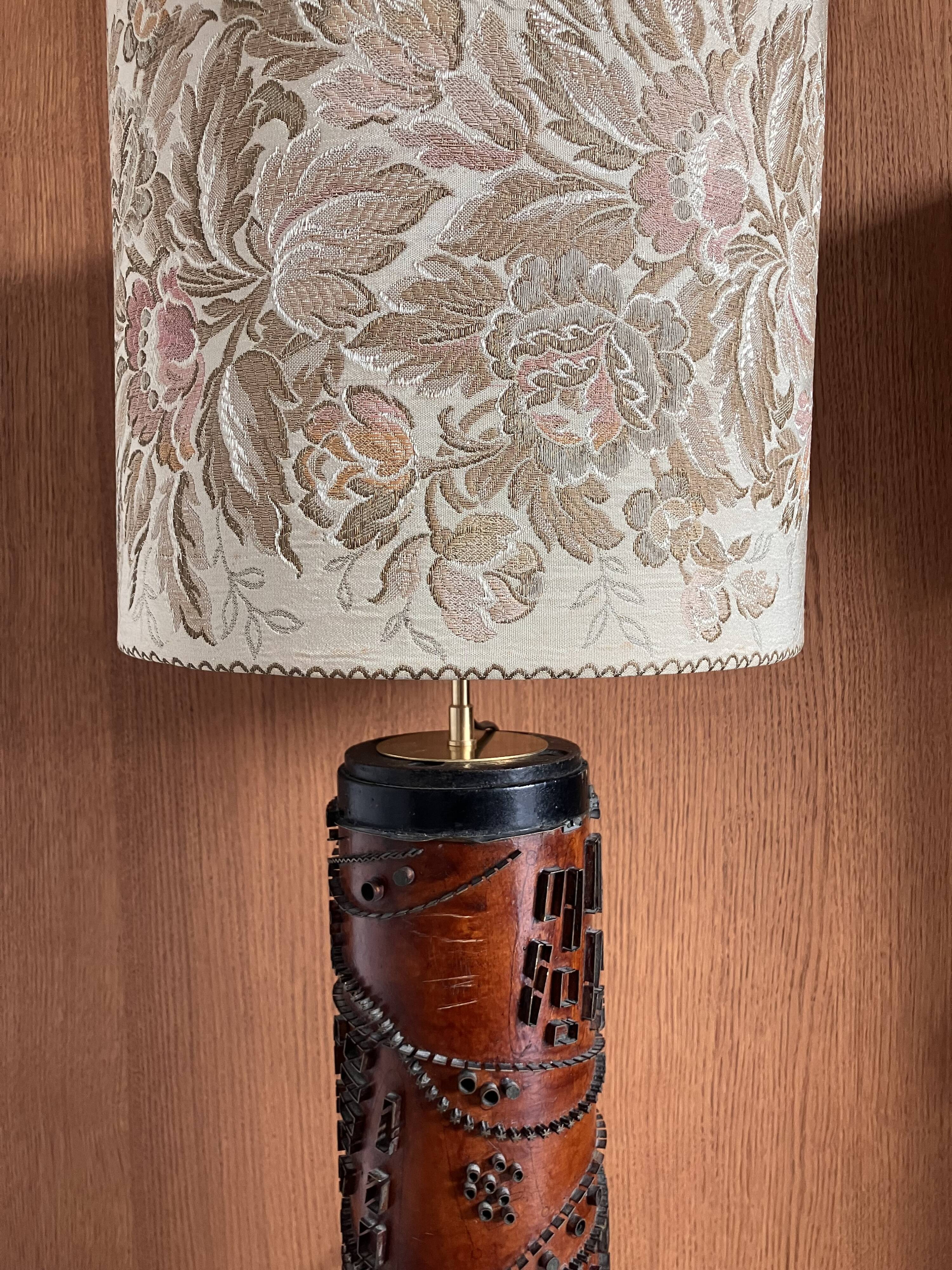 Table lamp with a solid wood printing roll and floral lampshade.