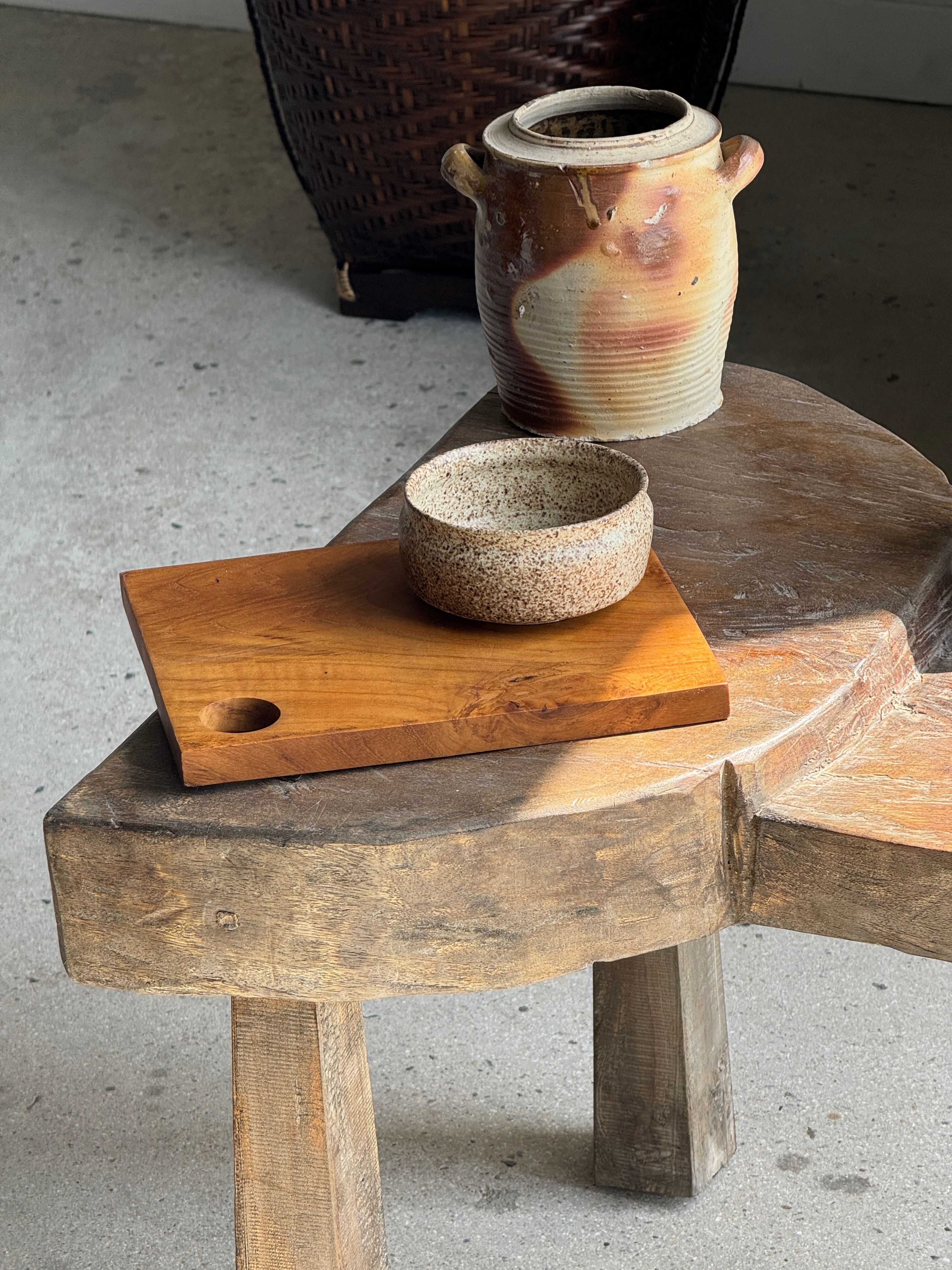 Small rectangular teak monoxyle cutting board with a circular handle.