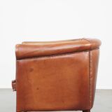 Cognac-colored cow leather club chair finished with decorative nails in English style