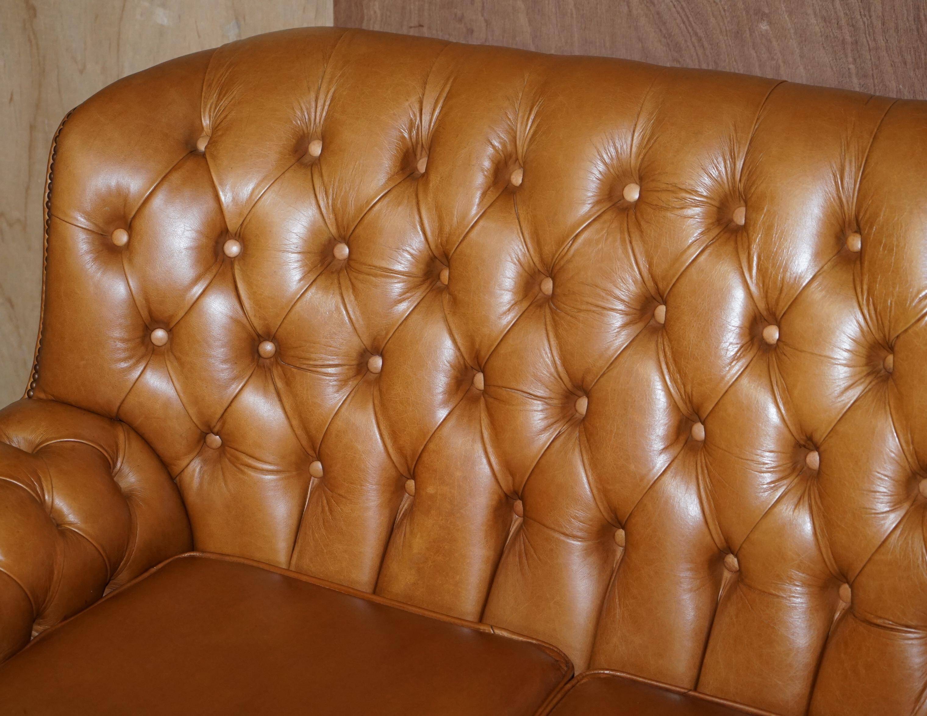 Small Chesterfield leather sofa with a high back.