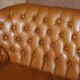 Small Chesterfield leather sofa with a high back.