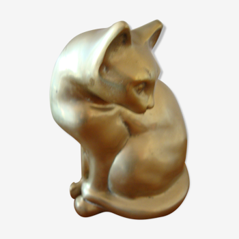 Cat sitting in brass