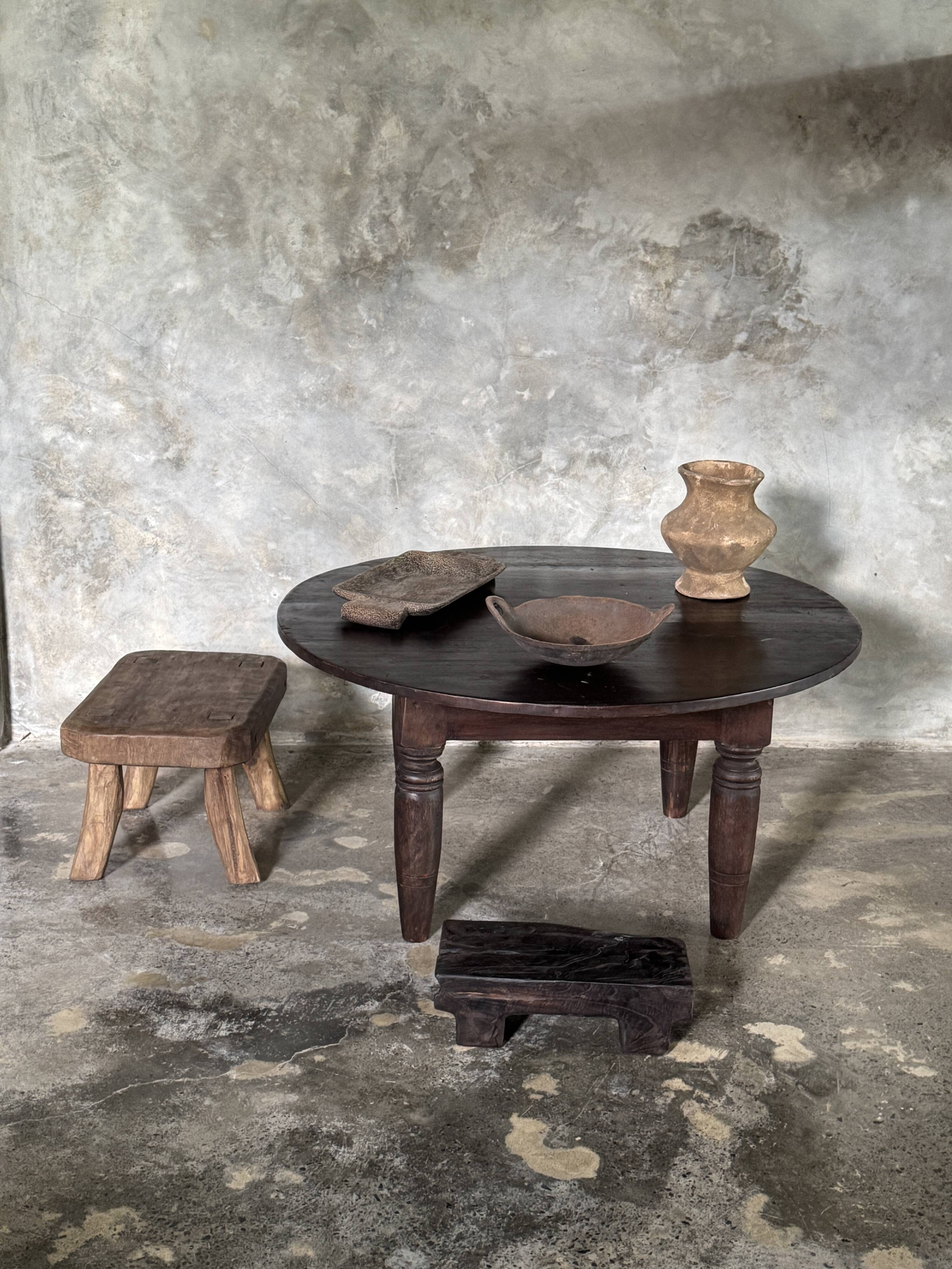Antique round coffee table in Indonesian teak with turned legs.