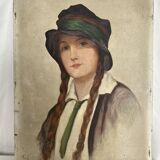 Old portrait of a young woman with braids and a hat, circa 1930