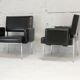 Paire de fauteuils piètement inox, simili-cuir noir, France, circa 1970