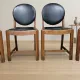 Set of four vintage wooden dining chairs with black leather upholstery, 85 × 45 × 45 cm