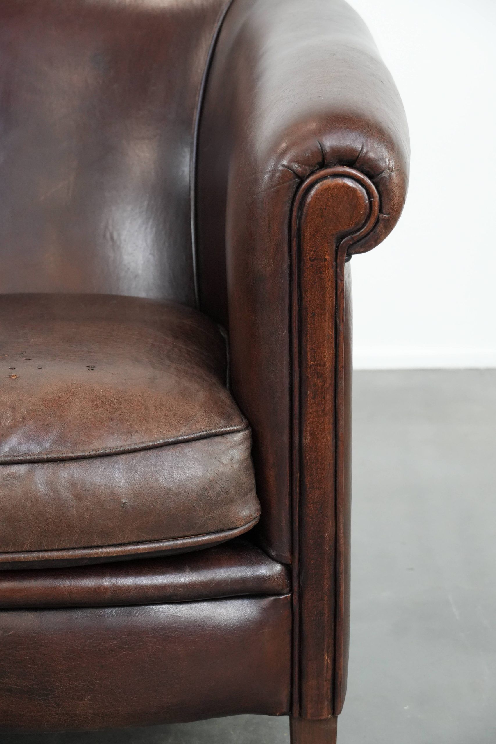 Stylish and sturdy dark brown club armchair made of sheepskin leather