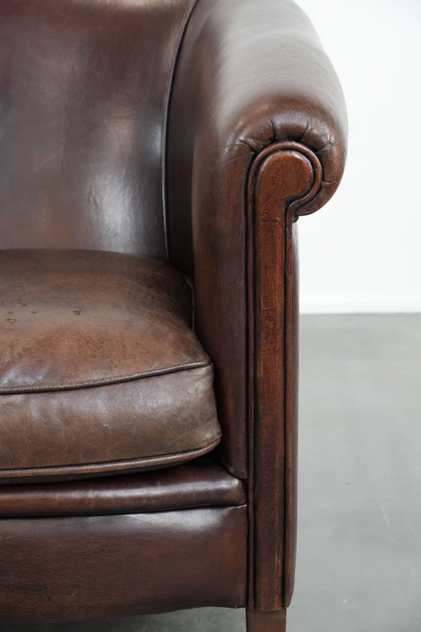 Stylish and sturdy dark brown club armchair made of sheepskin leather