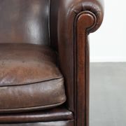 Stylish and sturdy dark brown club armchair made of sheepskin leather