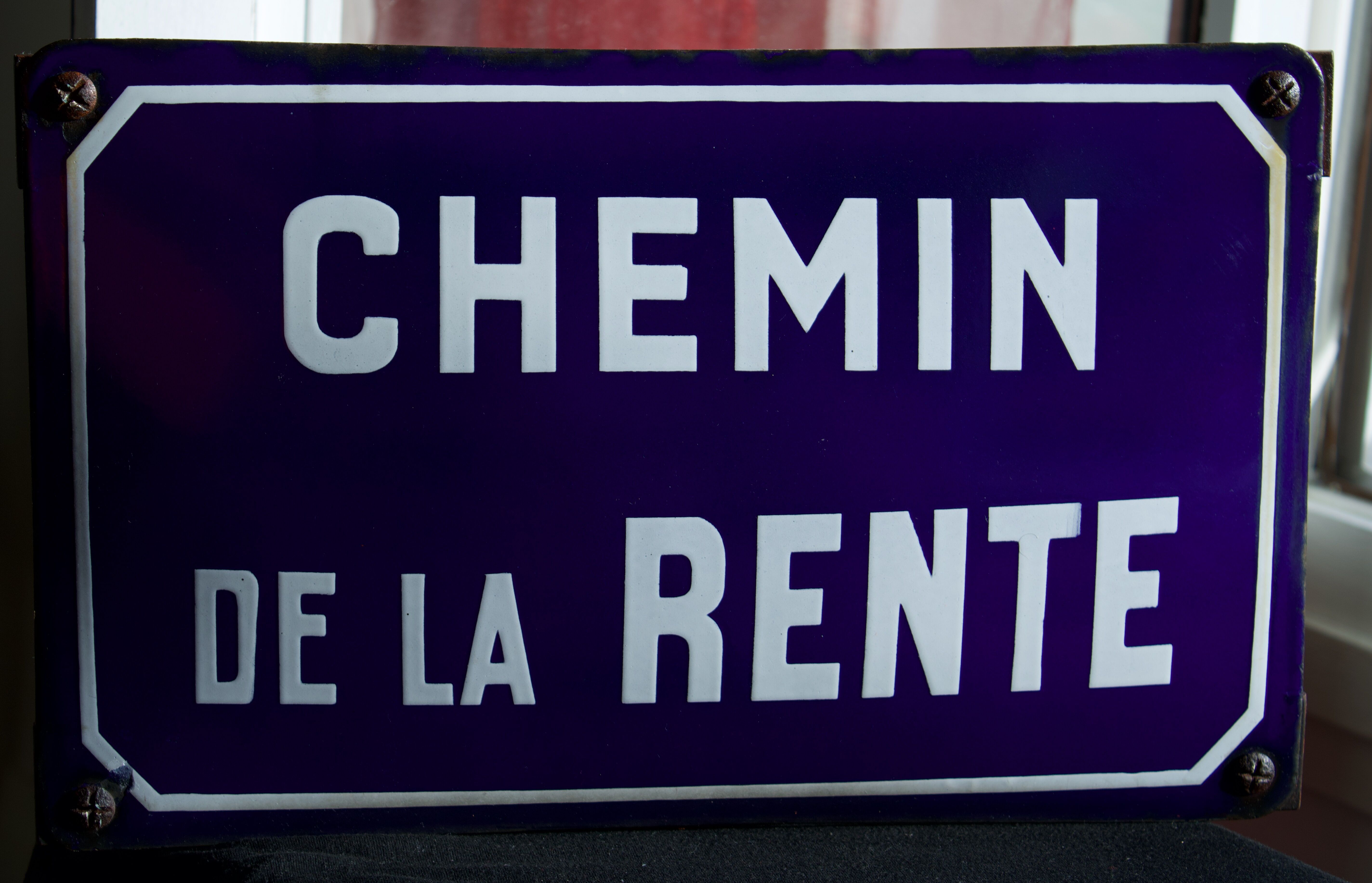 Old Enamelled and bulging "Chemin de la Rente" street plate, in perfect condition, on its cast iron support