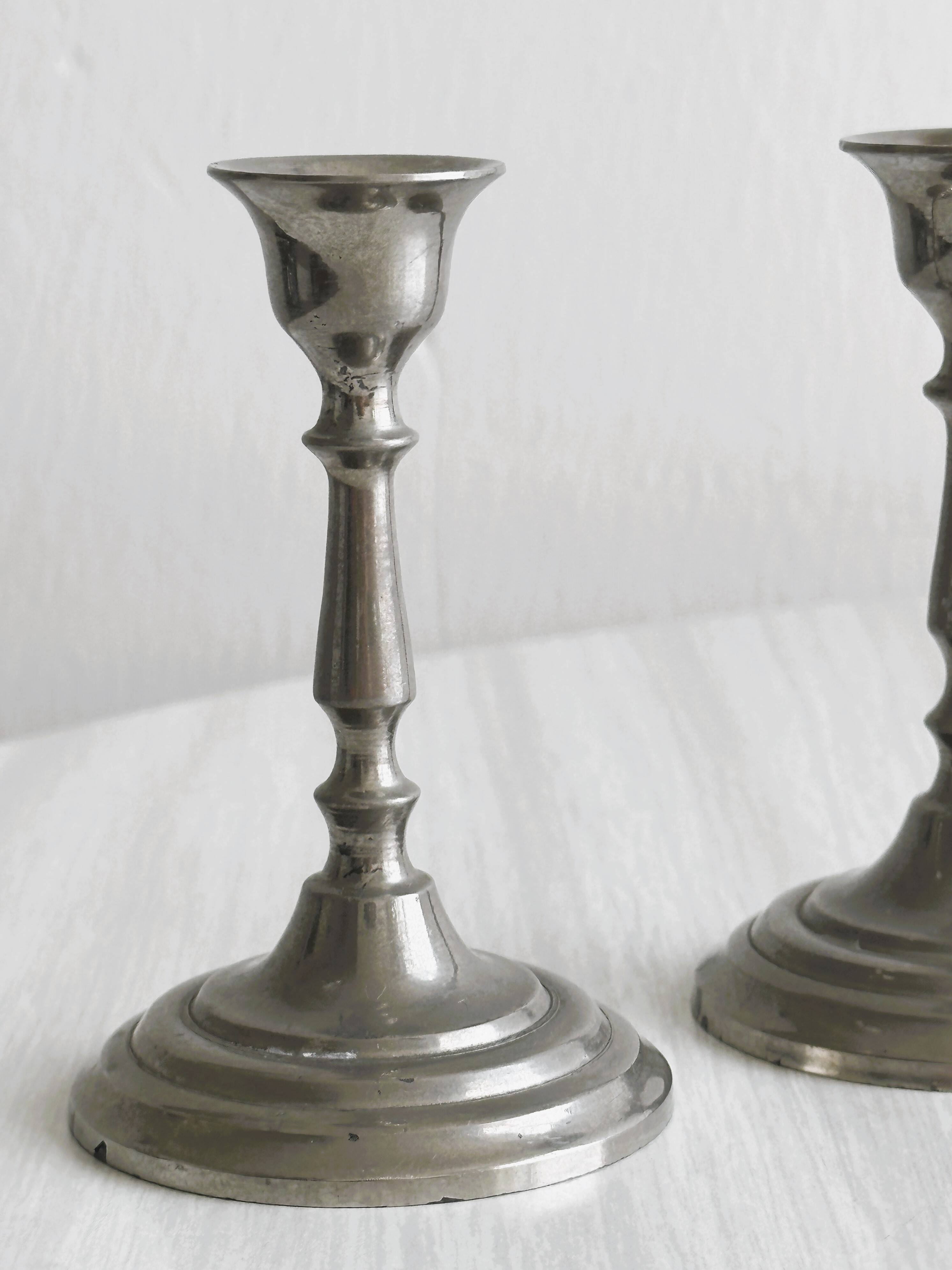 Pair of small metal candle holders, classic design.