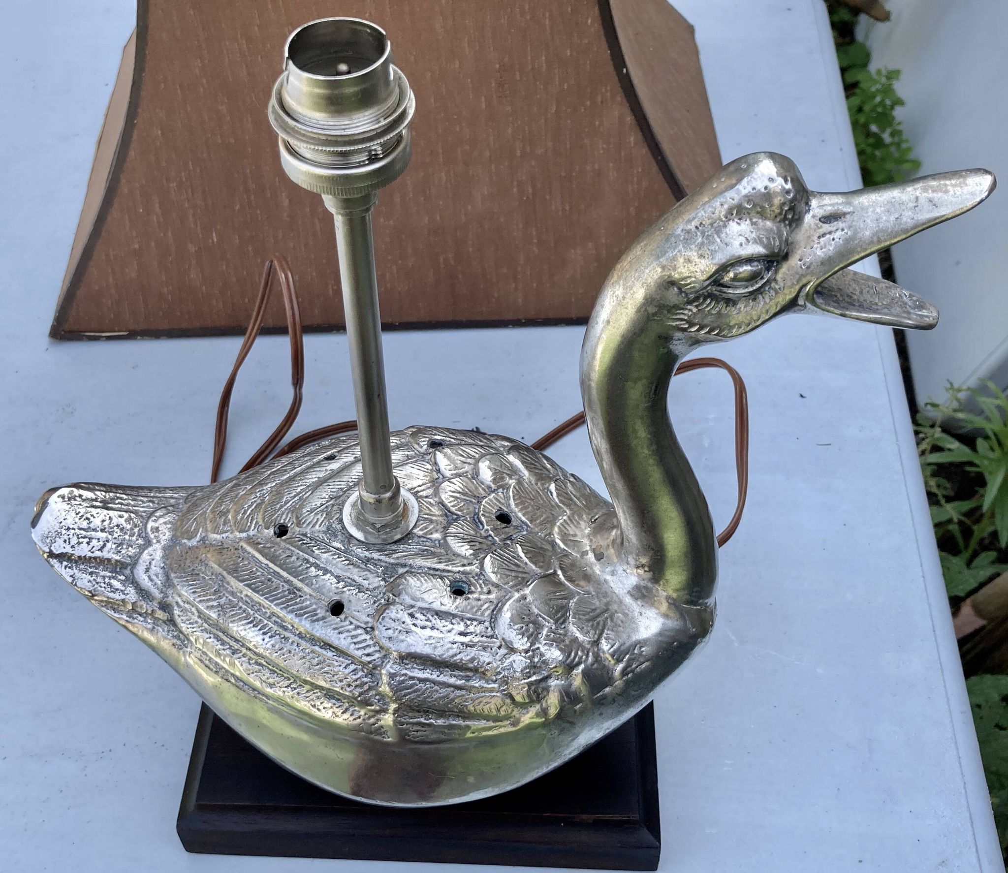 Old vintage lamp representing a duck in silver metal with wooden base