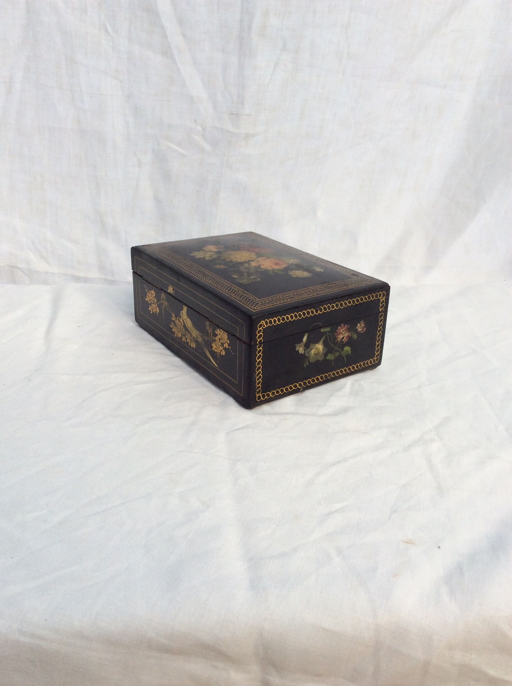 Old black wooden box adorned with roses with keys