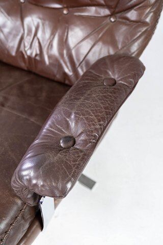 Easy chair upholstered with patinated brown leather and frame in metal, designed by Arne Norell