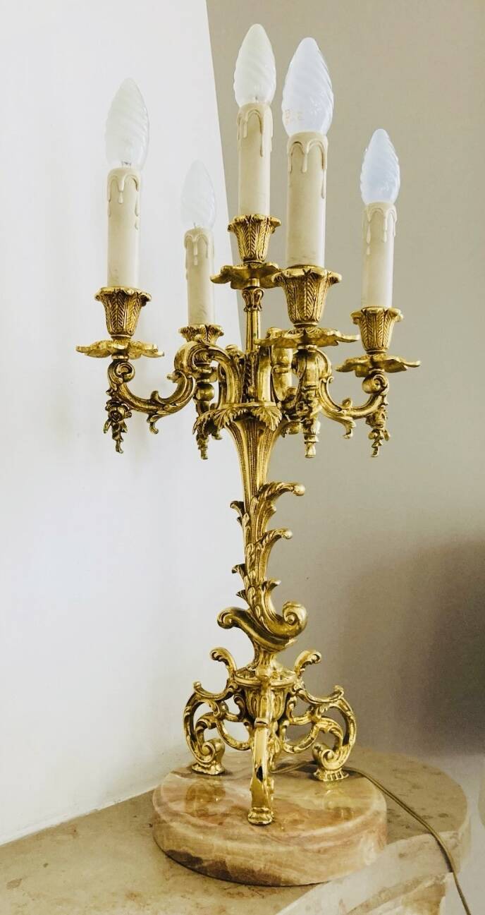Massive gilded bronze chandeliers from the mid-20th century with marble bases.