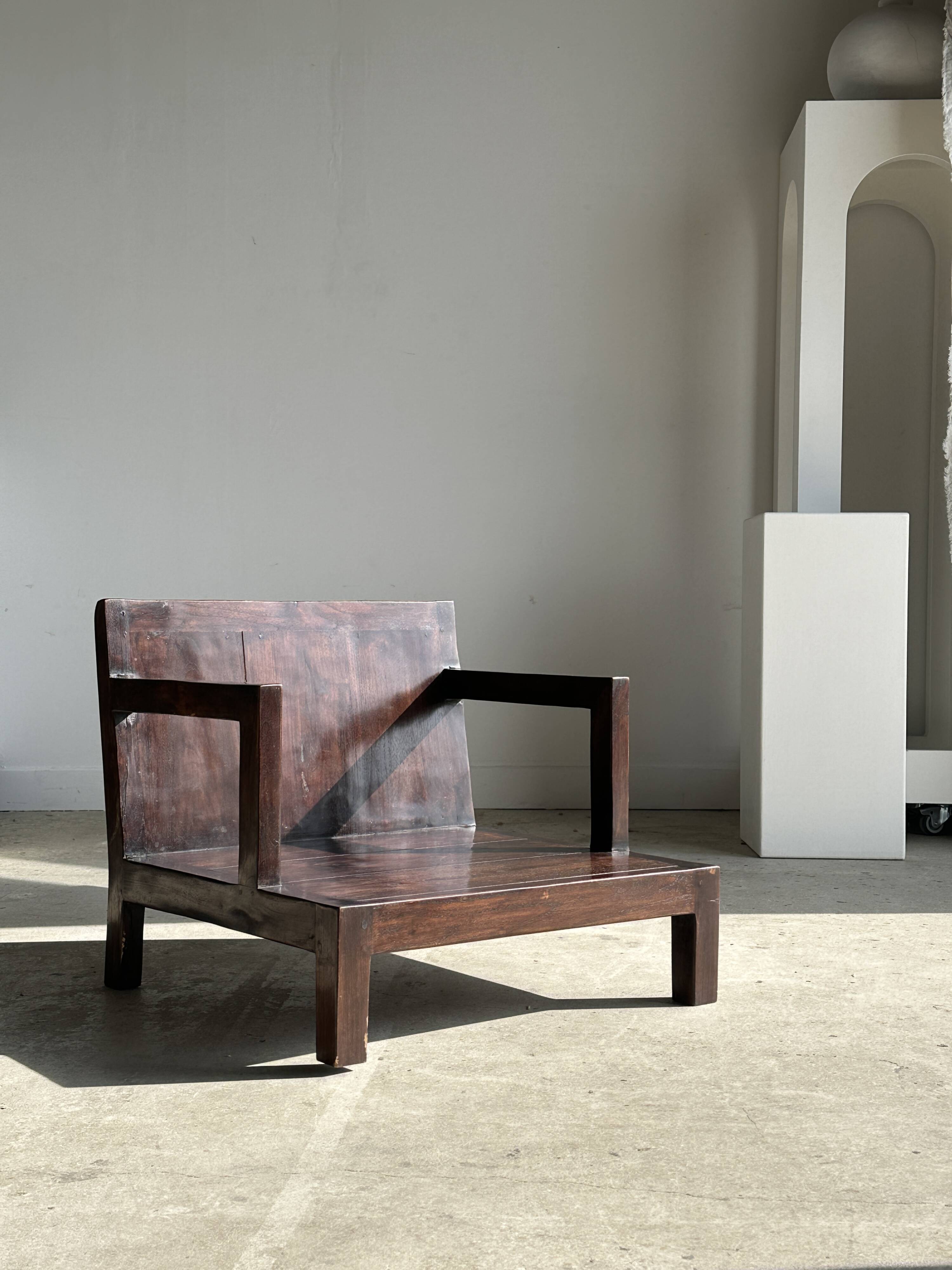 Small low armchair in varnished brown wood